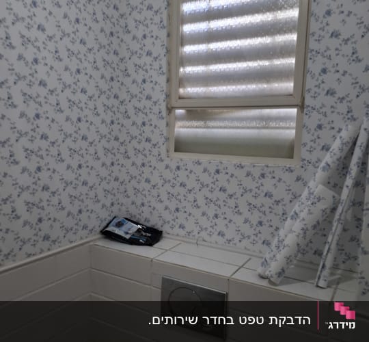קיר עם טפט פרחוני כחול ולבן בחדר אמבטיה